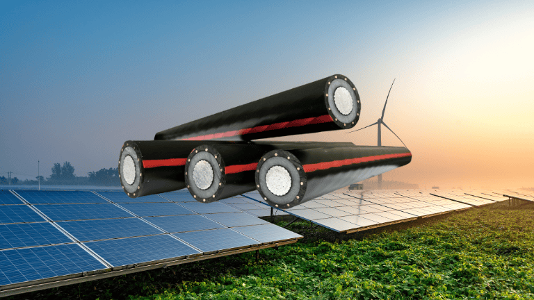 Imagen compuesta de tres grandes cables de media tensión sobre paneles solares y un aerogenerador en un campo verde, entrelazados con cables de media tensión, que simbolizan el almacenamiento de energía renovable.